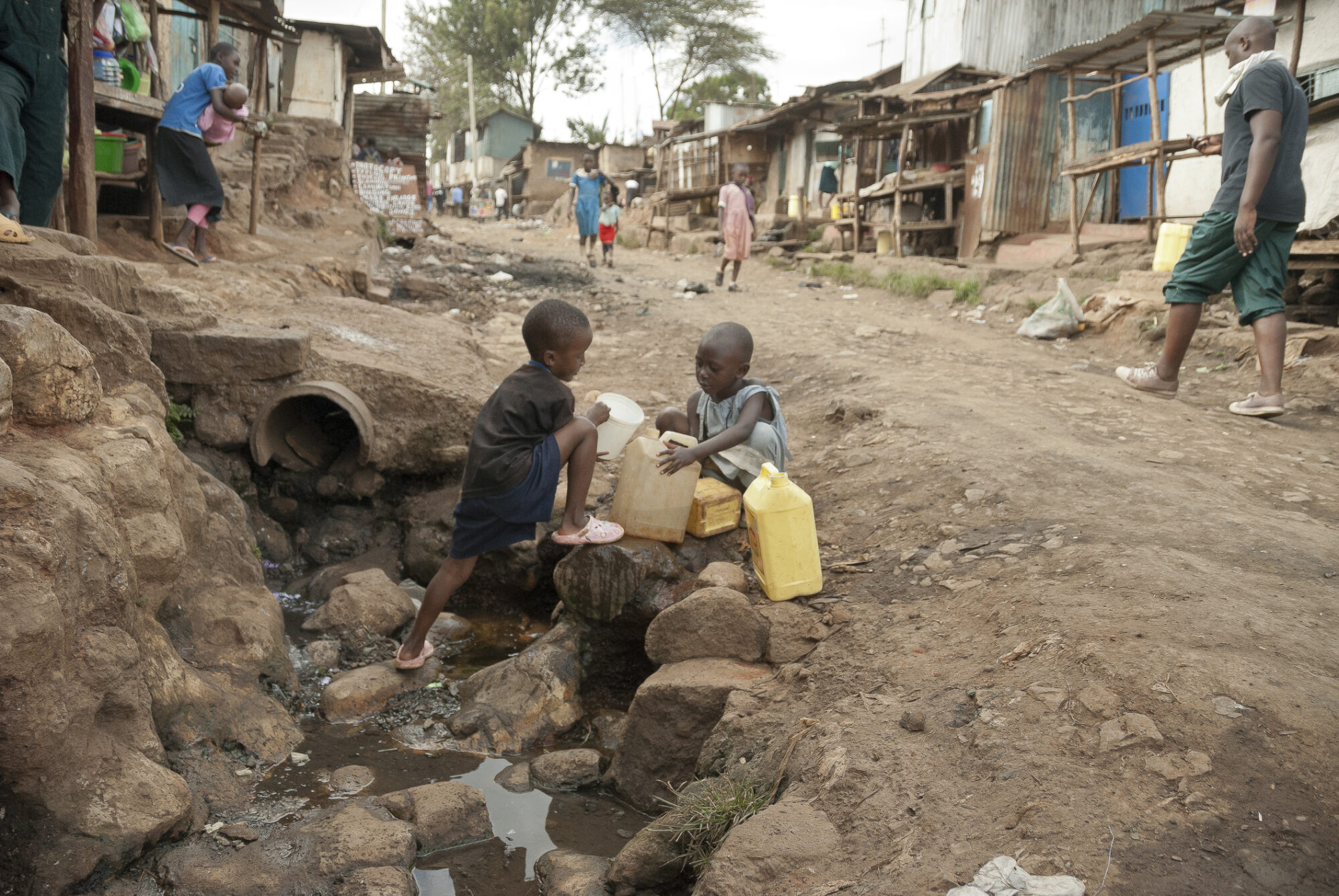 Boys take water on a street of Kibera, Nairobi, Kenya.